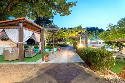 a garden with a pergola and a patio at Villa Rafaela in Koskinou