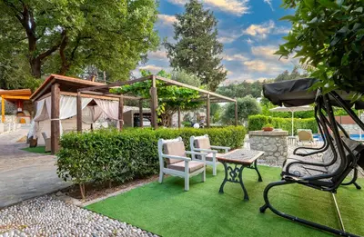 a garden with a table and chairs on grass at Villa Rafaela in Koskinou