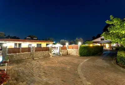 a house with a brick driveway at night at Villa Rafaela in Koskinou