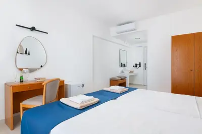 a bedroom with a large bed with a desk and a mirror at Lindos Nest in Pefki Rhodes