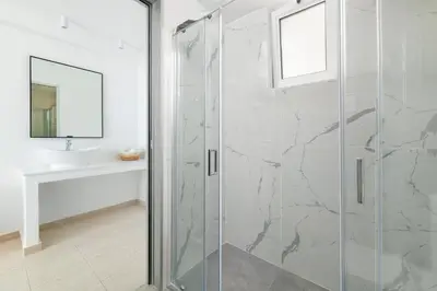 a glass shower in a bathroom with a sink at Lindos Nest in Pefki Rhodes