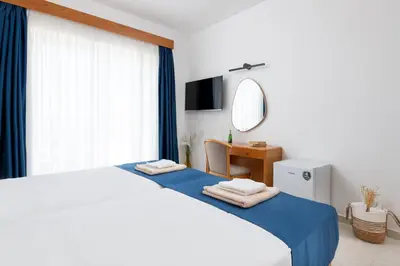 a bedroom with a bed and a desk and a mirror at Lindos Nest in Pefki Rhodes
