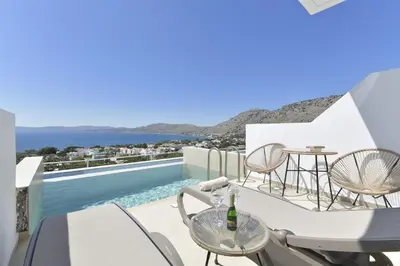 a balcony with a table and chairs and a swimming pool at Lindos Nest in Pefki Rhodes