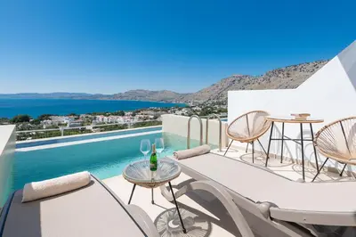 a balcony with a table and chairs and a pool at Lindos Nest in Pefki Rhodes
