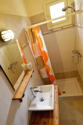 a small bathroom with a sink and a shower at Mango Rooms in Rhodes Town