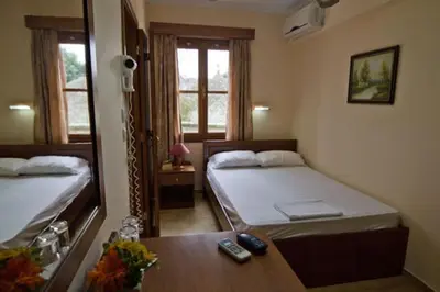 a small room with two beds and a table at Mango Rooms in Rhodes Town