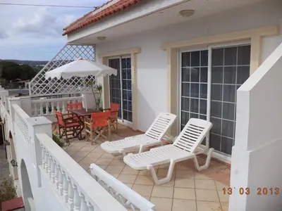 a balcony with white chairs and a table and a table and chairs at COLONIAL FAMILY apartment #3 in Faliraki