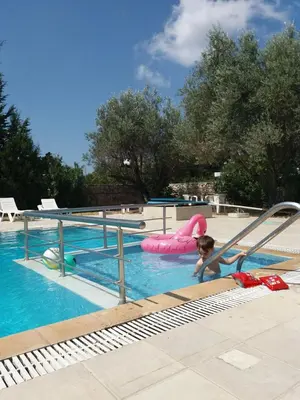 a young child playing in a swimming pool at COLONIAL FAMILY apartment #3 in Faliraki