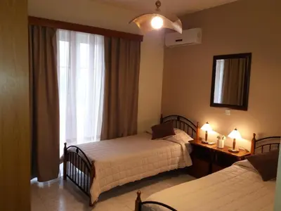 a hotel room with two beds and a window at COLONIAL FAMILY apartment #3 in Faliraki