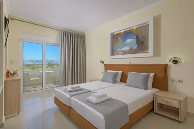 a bedroom with a large bed and a balcony at Astronomy Studios in Faliraki