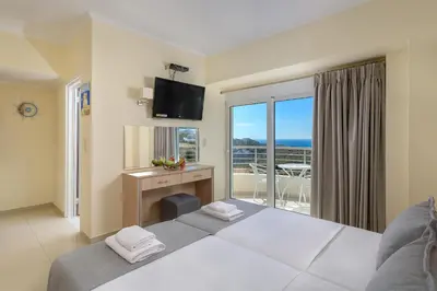 a hotel room with a bed and a view of the ocean at Astronomy Studios in Faliraki