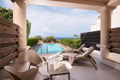 a patio with chairs and a swimming pool at KRESTEN ROYAL Euphoria Resort in Kallithea Rhodes
