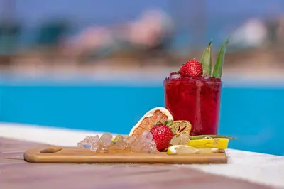 a drink sitting on a table with strawberries on it at KRESTEN ROYAL Euphoria Resort in Kallithea Rhodes