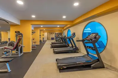 a gym with a row of treadmills and ellipticals at KRESTEN ROYAL Euphoria Resort in Kallithea Rhodes