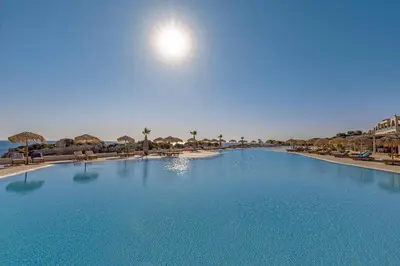 a large blue swimming pool with chairs and umbrellas at KRESTEN ROYAL Euphoria Resort in Kallithea Rhodes