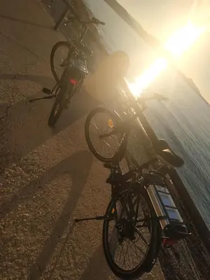 a bike parked on the beach with the sun shining at Villa Imerti Kiotari in Kiotari