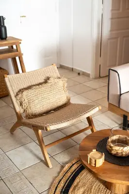 a rattan chair in a living room with a table at Villa Antonis in Halki