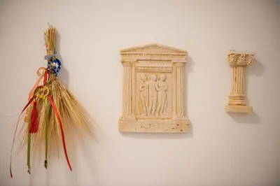 a wall with a carving of a woman and a column at Pantheon Deluxe Apartments in Archangelos