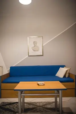 a blue couch with a coffee table in a room at Pantheon Deluxe Apartments in Archangelos