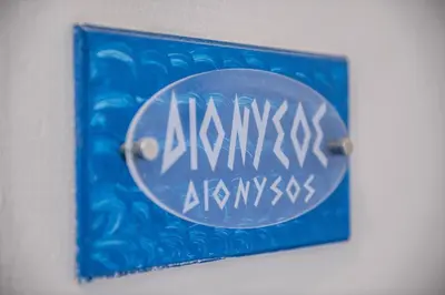 a blue picture with writing on it on a wall at Pantheon Deluxe Apartments in Archangelos