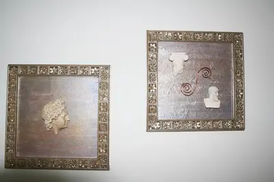 two framed pictures of a head on a wall at Pantheon Deluxe Apartments in Archangelos