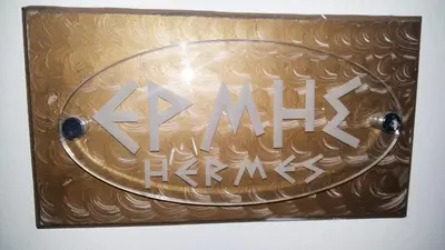 a gold sign with the word akmal on it at Pantheon Deluxe Apartments in Archangelos