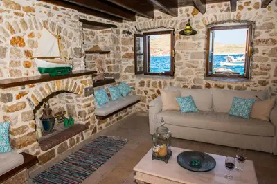 a living room with a stone fireplace and couches at Halkis Muses in Halki