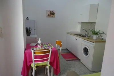 a kitchen with a table and a washing machine at Green Garden Studios in Koskinou