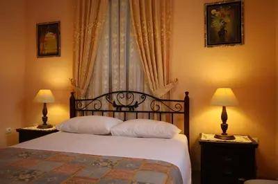a bedroom with a bed with two lamps and a window at Sofia Pension in Rhodes Town