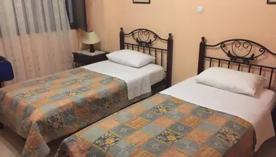 a bedroom with two beds and a lamp at Sofia Pension in Rhodes Town
