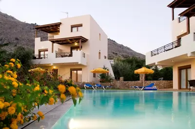 a hotel with a swimming pool in front of a building at Blue Dream Luxury Villas in Pefki Rhodes
