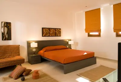 a bedroom with a bed and a chair in it at Blue Dream Luxury Villas in Pefki Rhodes