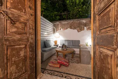an open door to a living room with a couch and a table at Aelia mini villa in Líndos