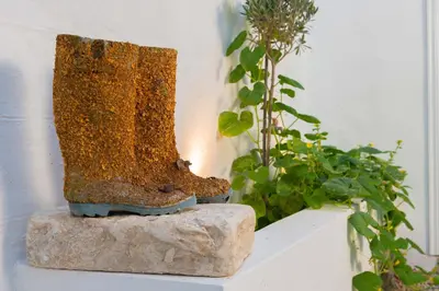 a fake boot sitting on a rock next to some plants at Aelia mini villa in Líndos