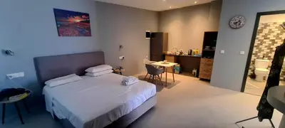a bedroom with a bed and a table and a bathroom at Jack Daniel Friends in Faliraki