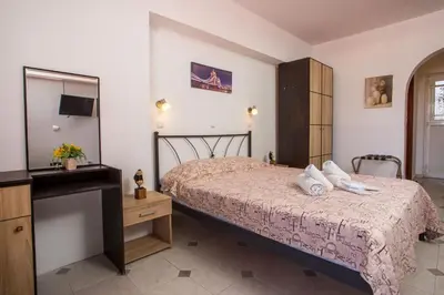 a bedroom with a bed with a dresser and a mirror at Jack Daniel Friends in Faliraki