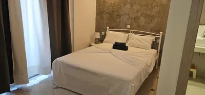 a small bedroom with a bed with white sheets and pillows at Jack Daniel Friends in Faliraki