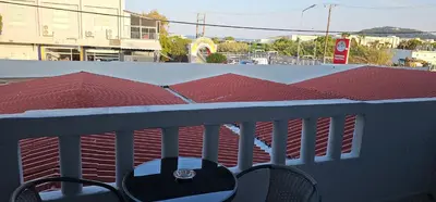a balcony with a table and chairs on a roof at Jack Daniel Friends in Faliraki