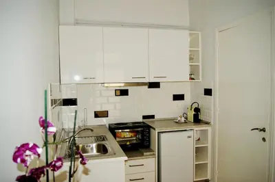 a kitchen with white cabinets and a sink at Kathopouli Apartment in Rhodes Town