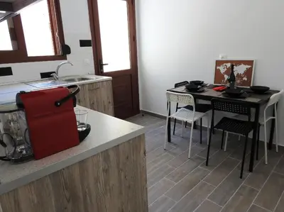 a kitchen with a counter and a table with a red suitcase at Kathopouli Apartment in Rhodes Town