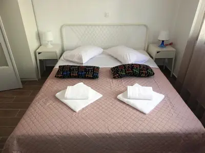 a bed with white towels and pillows on it at Kathopouli Apartment in Rhodes Town
