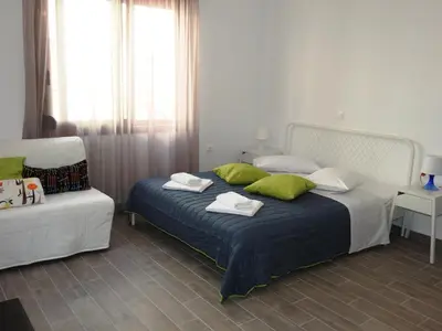 a bedroom with a bed with green and white pillows at Kathopouli Apartment in Rhodes Town