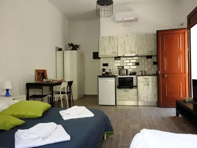 a room with a kitchen and a bed and a table at Kathopouli Apartment in Rhodes Town