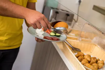 a man holding a plate with food on it at Dias Studios & Suites in Faliraki
