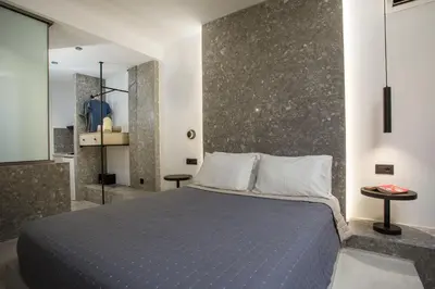 a bedroom with a king sized bed and a mirror at Dias Studios & Suites in Faliraki