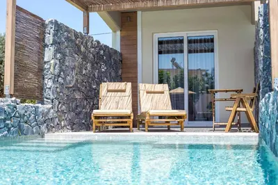 a pair of chairs sitting next to a swimming pool at Dias Studios & Suites in Faliraki