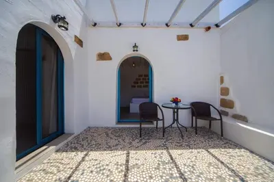 a room with two chairs and a table in it at Pontoria Stegna Studios in Archangelos