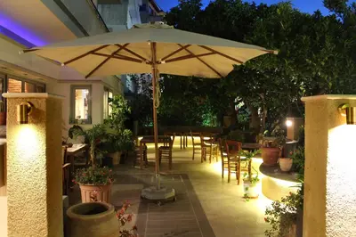 a patio with an umbrella and tables and chairs at Philoxenia Hotel & Studios in Rhodes Town
