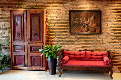 a red couch sitting in front of a brick wall at Philoxenia Hotel & Studios in Rhodes Town