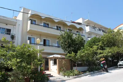 a large white building with trees in front of it at Philoxenia Hotel & Studios in Rhodes Town